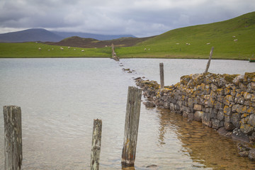 Fototapeta na wymiar Versunkene Trockensteinmauer in der Nähe von Durness, Lairg, Schottland