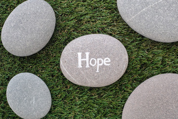 Hope. Bunch of stones lying on green grass - Powered by Adobe
