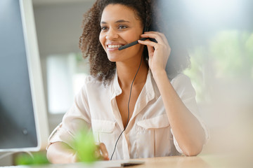 Portrait of customer service assistant talking on phone - obrazy, fototapety, plakaty