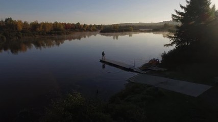 Homme observant le lac sur un ponton au Canada