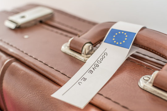 Old leather suitcase with eu flag and "goodbye eu" tag - metaphor of brexit.