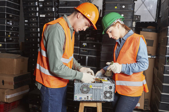Workers in computer recycling plant cleaning pc casing