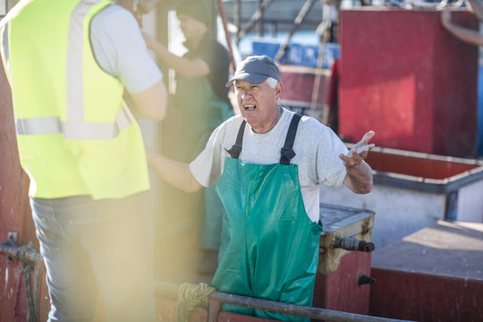 Fisherman on trawler talking to inspector