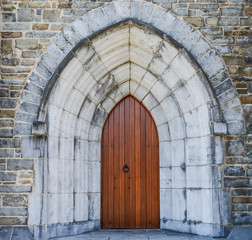 Fototapeta na wymiar Stone wall, wooden Door and archway of old medieval Church 
