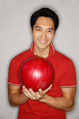 Man looking at camera, holding bowling ball