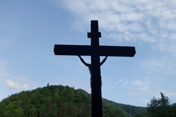 Sign of faith. Wooden cross in a cloudy sky