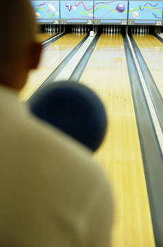 Man bowling, over the shoulder view