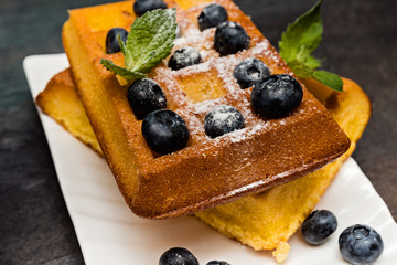 Belgium waffles with blueberries on wooden table, selective focus