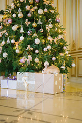 rabbit under the Christmas tree in a luxurious interior