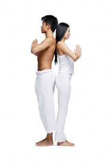 Obraz premium Couple doing yoga position, standing back to back