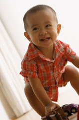 Young boy trying to stand, smiling