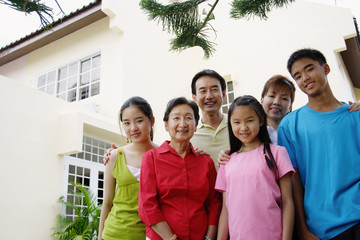 Three generation family, standing, looking at camera