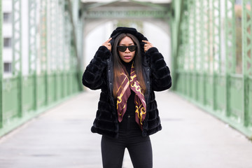 Fototapeta premium Beautiful black woman with sunglasses posing on street