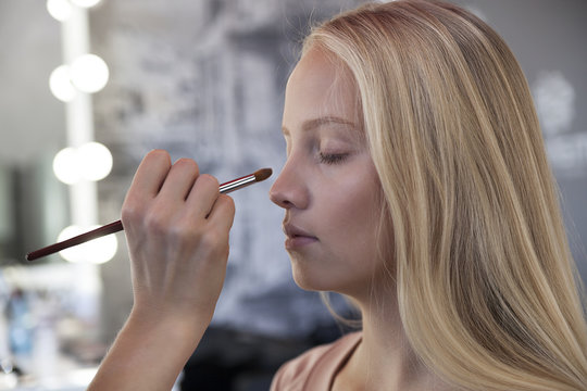 makeup,
beautiful young blond woman doing makeup