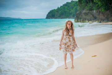 The girl walks on the water's edge on the Boracay