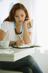 Obraz premium One woman sitting at table, writing