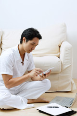 Man at home, using laptop and calculator