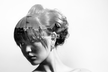 Monochrome double exposure of bride with beautiful hairdo and city skyline