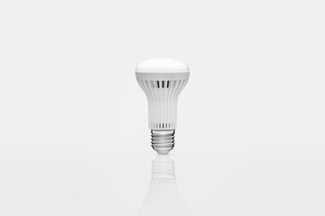 one energy saving lamp on a white background with reflection