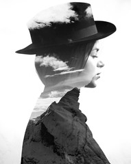 Monochrome double exposure of girl wearing hat profile and mountainscape