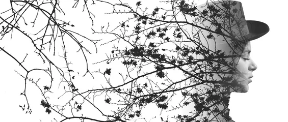Monochrome double exposure of girl wearing hat and tree branches © patronestaff