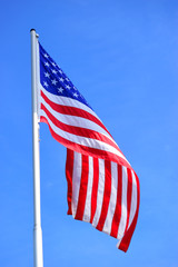 Obraz premium The American flag waving in blue sky