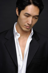 Man in white shirt and jacket, looking down