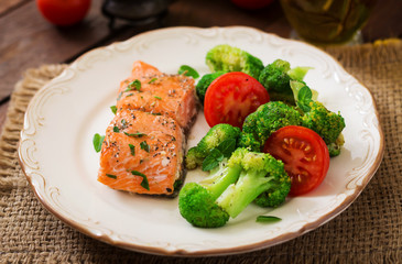 Baked fish salmon garnished with broccoli and tomato. Dietary menu. Fish menu. Seafood - salmon.
