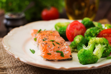 Baked fish salmon garnished with broccoli and tomato. Dietary menu. Fish menu. Seafood - salmon.
