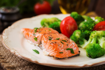 Baked fish salmon garnished with broccoli and tomato. Dietary menu. Fish menu. Seafood - salmon.