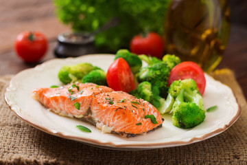 Baked fish salmon garnished with broccoli and tomato. Dietary menu. Fish menu. Seafood - salmon.