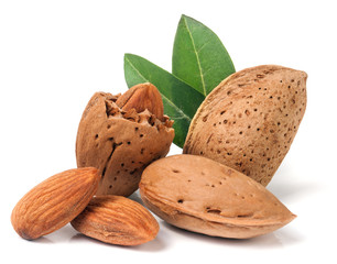 almonds in their skins and peeled with leaf isolated on white background