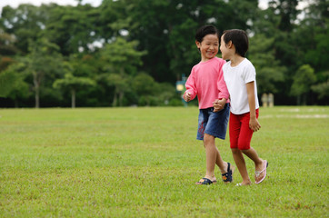 Obraz premium Two girls walking in park, holding hands