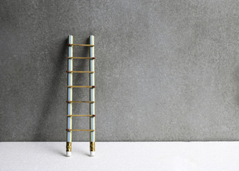 Pencil ladder leaning against grunge wall with copy space. succe