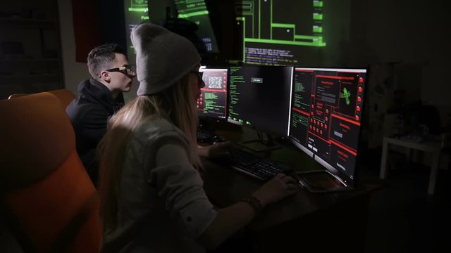 Team of hackers, hacking computers, working in dark room. HD