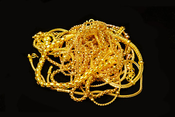 Group of many design gold jewelry on black background