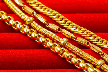Group of many design gold jewelry on red background