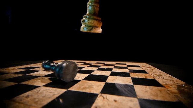 A white chess piece king overthrows the black king on a chess board