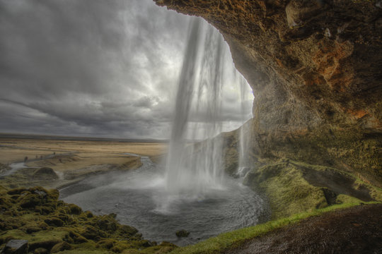 Waterfall cascading above rocks, Iceland