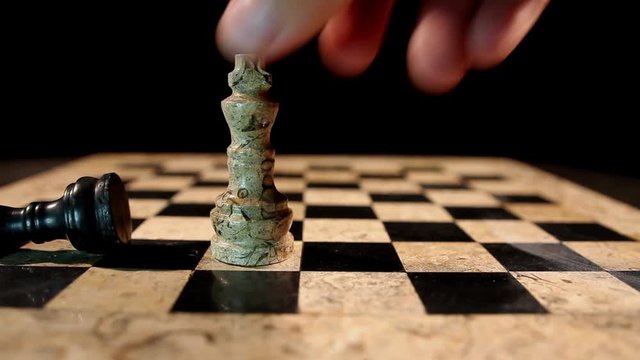 A white chess figure king overthrows a black king from the chess board and takes his place....