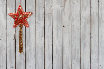 Weihnachtsstern aus Samt und Pailletten auf verwittertem Holzlattenhintergrund