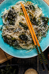 Funchoza salad with wakame on dark background. © tbralnina