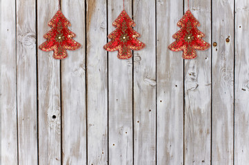 Dekoration mit Weihnachtsbäumen aus Samt und Pailletten auf verwittertem Holz