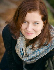 Fototapeta premium Outdoors portrait of beautiful young red haired woman looking at camera