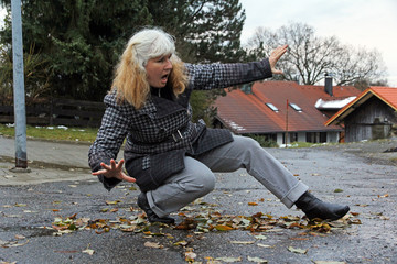 Eine Frau ist auf nassem Laub ausgerutscht