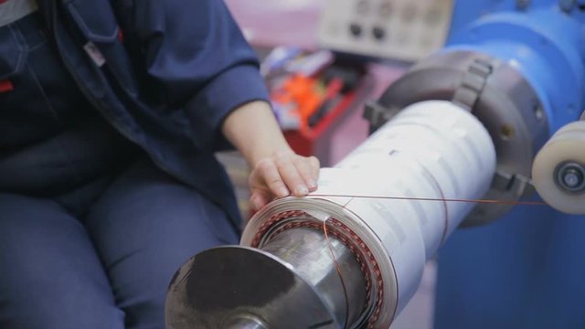 Worker operates with electric cooper wires, winding of the transformer. HD.