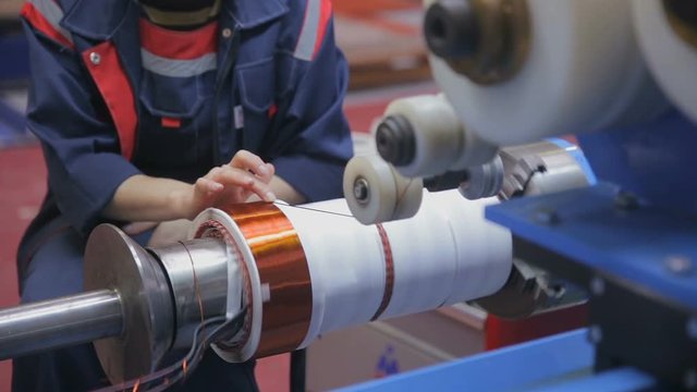 Worker operates with electric cooper wires, winding of the transformer. HD.