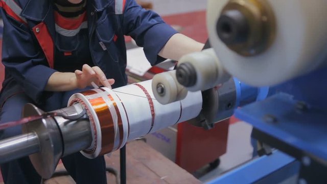Transformer, engine production. Worker winding cooper wires on a high voltage transformer. Slider shoot. HD.