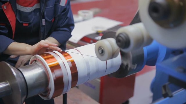 Transformer, engine production. Worker winding cooper wires on a high voltage transformer. Slider shoot. HD.