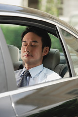 Businessman sitting in car, eyes closed
